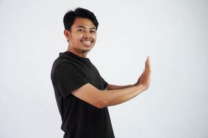 Young asian man wearing black t shirt gesture push his hands feels heavy isolated on white background photo