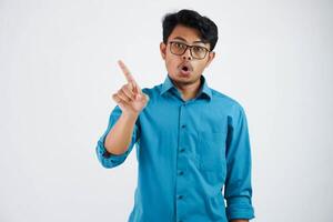 young Asian businessman wearing blue shirt with glasses show swing finger with disagree say no isolated on white background photo