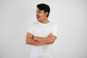 sonrisa o contento asiático hombre cruzado brazos vistiendo blanco t camisa aislado en blanco antecedentes foto