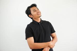 young asian Asian man relaxed and happy laughing, neck stretched showing teeth wearing black polo t shirt isolated one white background photo