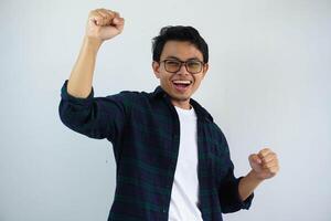 young asian man screaming success with his fist clenched isolated on white background photo