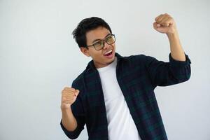 young asian man screaming success with his fist clenched isolated on white background photo