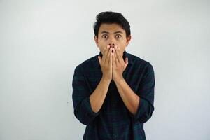 joven asiático hombre demostración conmocionado expresión con su manos cubierta boca aislado en blanco antecedentes foto