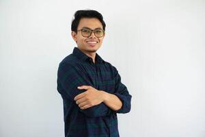 sonriente joven asiático hombre demostración contento expresión en pie confidente con brazos cruzado aislado en blanco antecedentes foto
