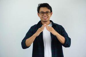 joven asiático hombre sonriente cuando haciendo triángulo forma con su mano aislado en blanco antecedentes foto