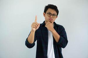 young asian man showing curious face expression while giving one fingers sign isolated on white background photo