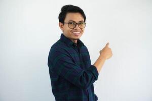 Side view of young Asian man smiling showing happy expression while pointing his behind isolated on white background photo