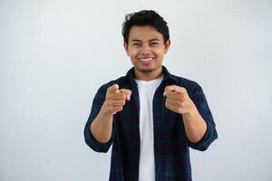 young asian man showing happy face expression while pointing forward isolated on white background photo