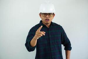 young asian architect man showing angry face expression while finger pointing forward isolated on white background photo