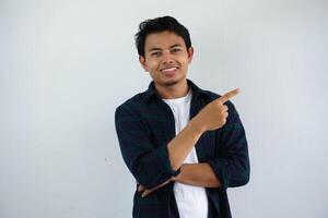 young asian man smiling happy with his right hand pointing to the left side isolated on white background photo