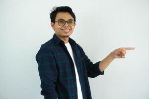 Side view of young Asian man smiling happy while pointing finger forward isolated on white background photo