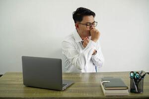 young asian businessman in a workplace is suffering with cough and feeling bad wear white shirt with glasses isolated photo