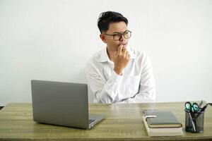 young asian businessman in a workplace nervous and scared, wearing white shirt with glasses isolated photo