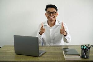 happy young asian businessman in a workplace pointing to the front and smiling wear white shirt with glasses isolated photo