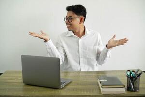 young asian businessman in a workplace holding copyspace with two hands, wearing white shirt with glasses isolated photo