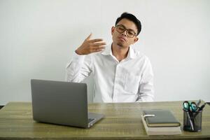 young asian businessman in a workplace with tired and sick expression, wear white shirt with glasses isolated photo
