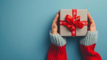 AI generated Person holding a festive Christmas gift box with a red ribbon, celebrating a joyful occasion with love and surprise photo