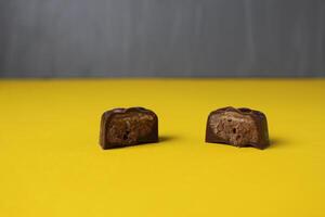 Chocolate Day. Close-up of chocolates on yellow grey background with space for copy space text photo