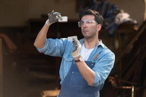 Carpenter working at his carpentry shop. Eyesight is utilized to ensure accuracy. photo