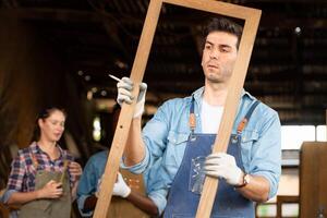 retrato de carpintero masculino trabajador en pie en frente de colega en taller, vista es utilizado a garantizar exactitud. foto