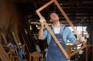 Carpenter working at his carpentry shop. Eyesight is utilized to ensure accuracy. photo