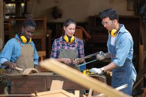 Carpenter and his assistant working together in a carpentry workshop photo