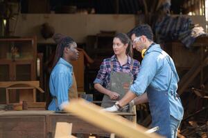 Carpenter and his assistant working together in a carpentry workshop photo