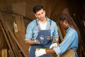 Carpenter and his assistant working together in a carpentry workshop photo