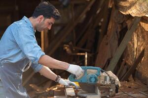 Portrait of a craftsman working with a circular saw at a wood workshop photo