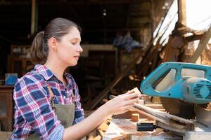 Portrait of female carpenter working in her workshop at countertop photo