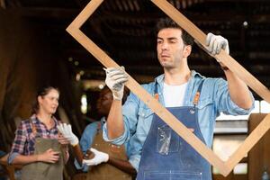 Portrait of carpenter male worker standing in front of colleague in workshop, Eyesight is utilized to ensure accuracy. photo