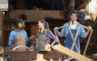 Carpenter and his assistant working together in a carpentry workshop photo
