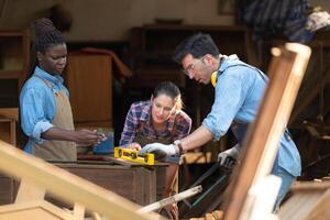 Carpenter and his assistant working together in a carpentry workshop photo