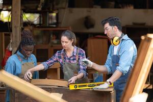 Carpenter and his assistant working together in a carpentry workshop photo