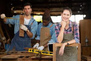 Portrait of carpenter female worker standing in front of colleague in workshop, Eyesight is utilized to ensure accuracy. photo