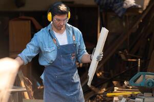 Portrait of a carpenter holding a spirit level in his workshop. photo