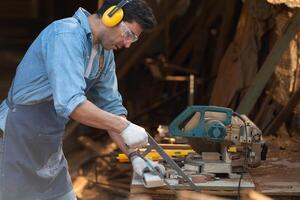 Portrait of a craftsman working with a circular saw at a wood workshop photo