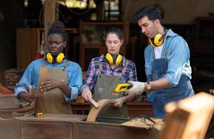 Carpenter and his assistant working together in a carpentry workshop photo