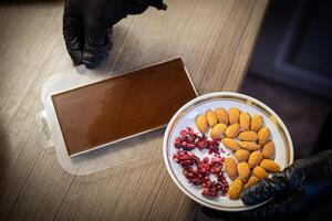 Woman cooking tasty melted chocolate on table in kitchen. photo