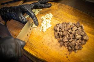 Woman cooking tasty melted chocolate on table in kitchen. photo