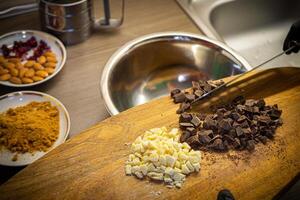 Woman cooking tasty melted chocolate on table in kitchen. photo