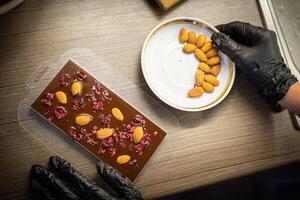 Woman cooking tasty melted chocolate on table in kitchen. photo