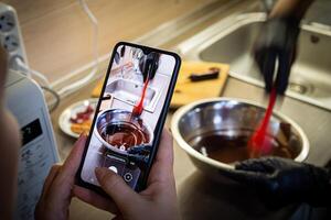 Woman cooking tasty melted chocolate on table in kitchen. photo