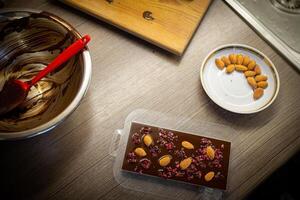 Woman cooking tasty melted chocolate on table in kitchen. photo