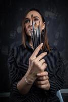 Portrait of a female artist, with brushes in her hands. photo