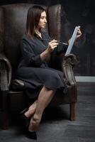 a young brunette female artist stands behind an easel. photo