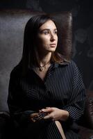 a young brunette female artist stands behind an easel. photo