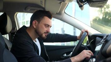 elegant Mens in een nieuw auto gebruik de sensor in de buurt bedrijf centrum video