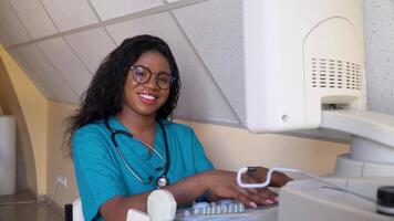 Smiling african american doctor working on ultrasound device video