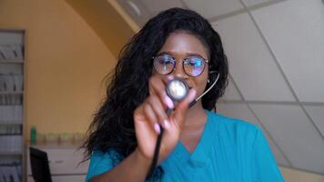 Happy african american woman physician or nurse professional general practitioner posing with stethoscope looking at camera in medical office. Concept of medicine, health care and people video